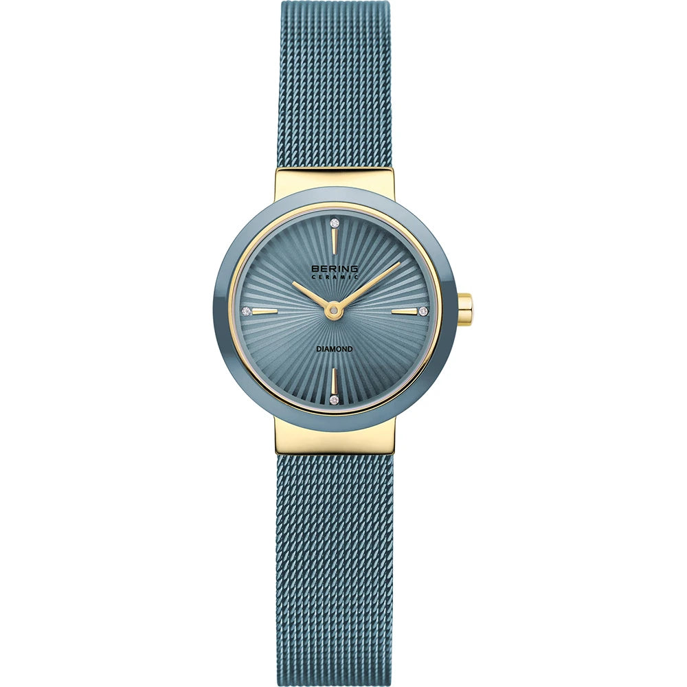 Introducing the Bering Watch - Diamond Collection - 10725-339 by Bering, a stylish ladies' timepiece featuring a blue mesh strap and a blue and gold round case. The striking blue sunburst dial is adorned with elegant gold hour markers, accented by small diamonds at the 3, 6, 9, and 12 o’clock positions.