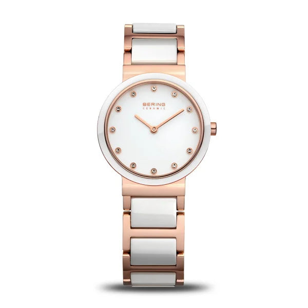 The Bering Watch - Ladies Ceramic with Pendant (10725-766) features a rose gold and white ceramic band, round white face, crystal hour markers, slim design, and gold hands. The BERING logo is displayed at the top.