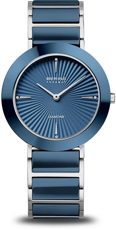 The Bering Watch - Blue Ceramic - 11435-707 is a stylish women’s quartz watch with a blue sunburst dial, minimal hour markers, and silver-tone hands. Its silver band features blue ceramic links and Diamond above 6 o’clock. Brand: Bering.