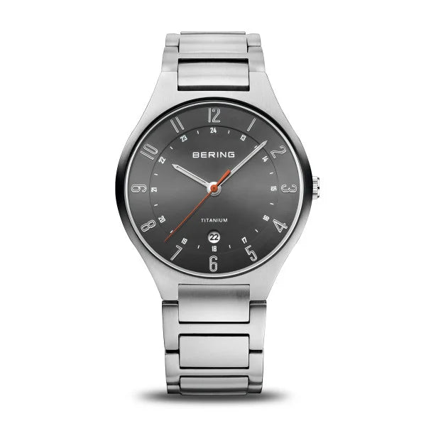 The Bering Watch - Ultra-Light Titanium Collection 11739-772 features a silver case, grey face with sapphire crystal, silver markers and hands, orange second hand, date at 6 oclock, dual 12/24-hour display, and a metal link bracelet.