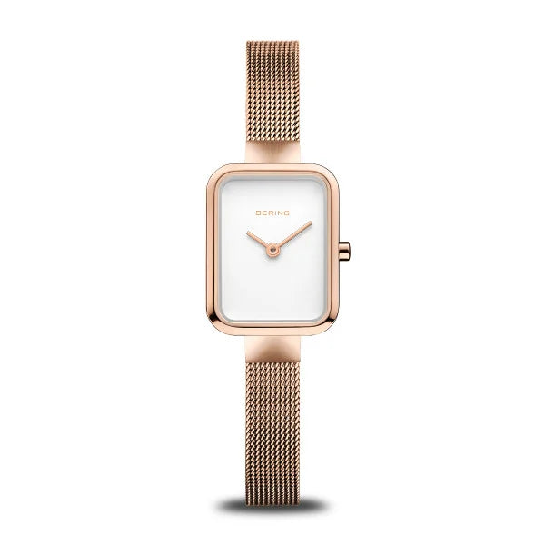 The Bering Watch - Petite Square Collection - 14520-364 features a rose gold rectangular case, minimalist white face, slender gold hands, and a mesh band from Bering, shown on a white background.