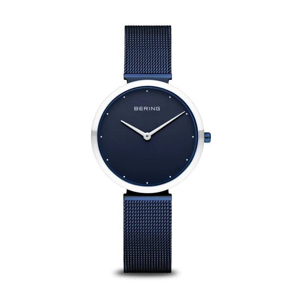 The Bering Watch - Ladies Polished Blue Classic Collection (18132-397) features a minimalist round blue face, silver hands, no numbers, and a blue mesh band from brand Bering, shown against a white background.