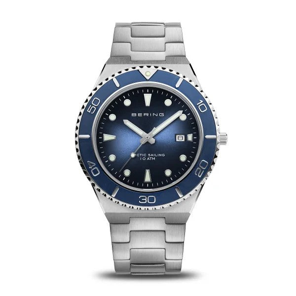 The Bering Watch - Arctic Sailing Collection Mens Blue (18940-707) features a blue bezel and dial, silver hour markers, date at 3 o’clock, stainless steel link band, and Arctic Sailing 10 ATM on the face. Brand: Bering.