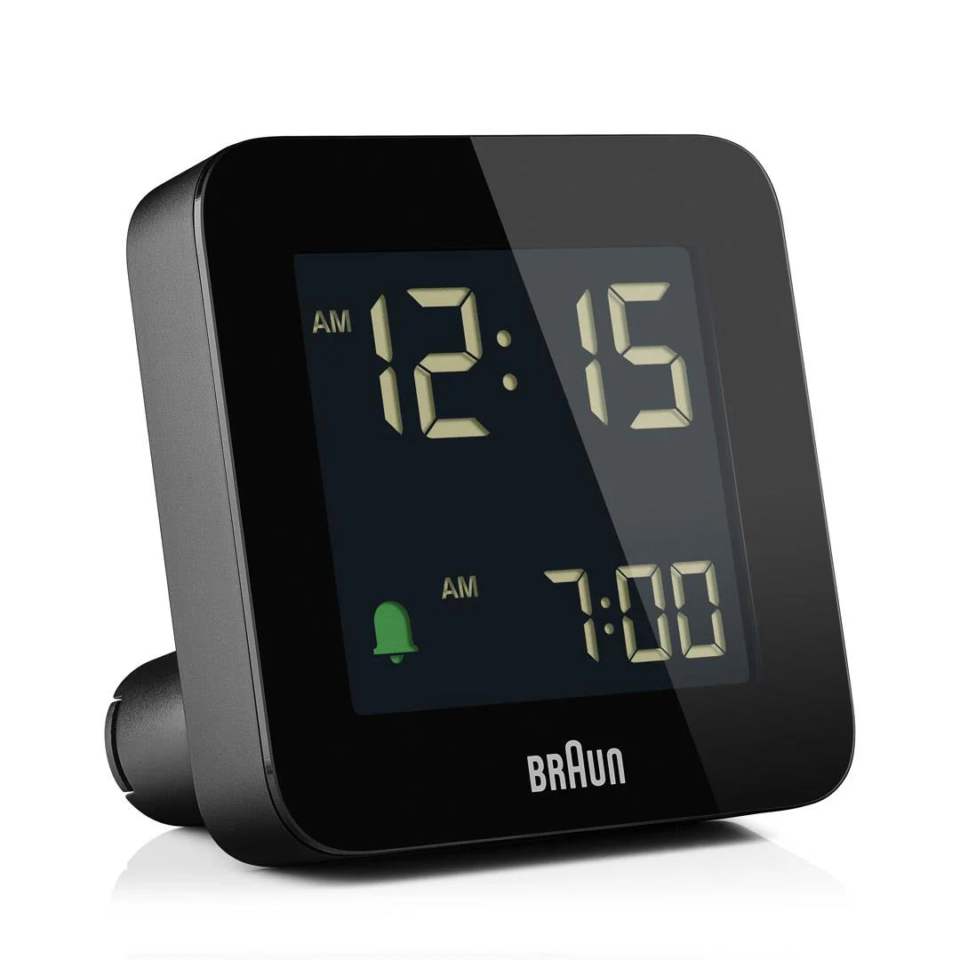 The Ameico Braun - Alarm Clock - BC09B features a minimalist black design, displays 12:15 AM with the alarm set for 7:00 AM, a green alarm icon on screen, and the Braun logo below the display.