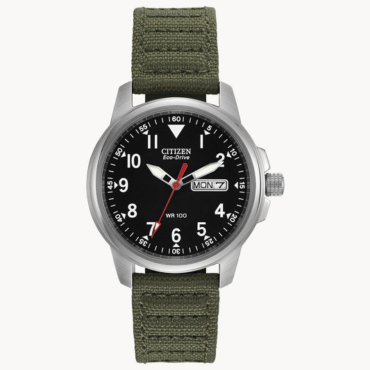 The Citizen Watch Chandler BM8180-03E by Citizen is a military-inspired timepiece with a black dial, white numerals, silver case, green fabric strap, day-date display (Monday 7), plus striking white and red hands.
