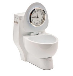 The Sanis Enterprises Sanis Mini Clock (Toilet White - C3200WH) cleverly merges a classic toilet design with a built-in mini clock in the lid for a unique and functional decor piece.