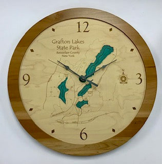 The Lake Art Lake Clock - Grafton Lakes Clock features a map of Grafton Lakes State Park, NY, with blue lakes on the face, a wood frame, black hands, and engraved numbers at 12, 3, 6, and 9.