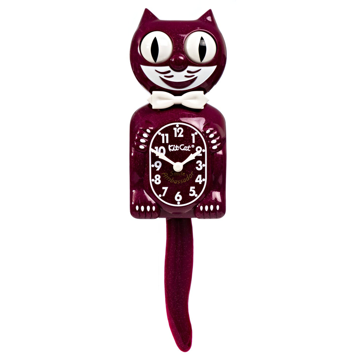 The California Clocks Kit-Cat Klock - Ruby Red Gent (BC-50) is shaped like a smiling cat with a white bow tie. Its eyes and tail are designed to move back and forth, and the clock face is centered on the cat’s belly.