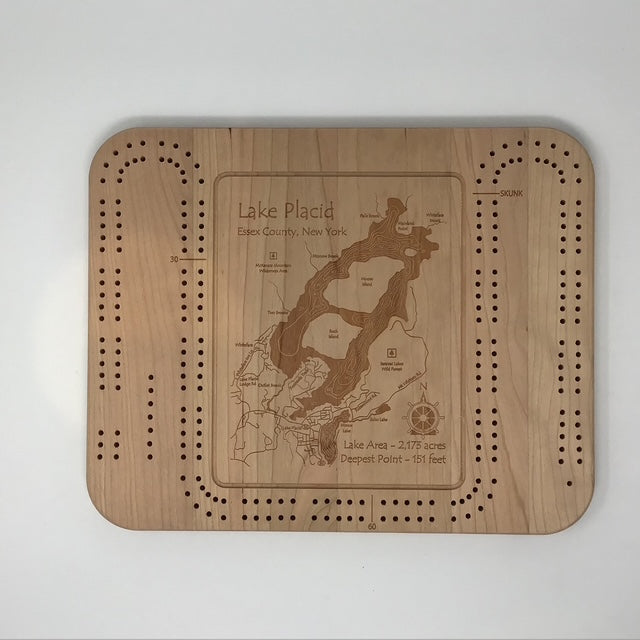 The Lake Art Lake Gift - Lake Placid Cribbage Board is crafted from cherry wood and engraved with Lake Placid, Essex County, NY, including the lake’s area and depth, plus cribbage peg holes for a unique board game experience.