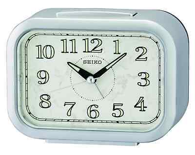 The Seiko QHK056S is a rectangular silver alarm clock with black numbers and hands, a simple classic design, and the Seiko brand printed below the 12; time shown is 10:10.