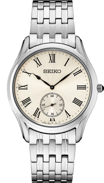 The Seiko Watch - Essentials - SRK047 features a silver metal link band, cream dial, black Roman numeral markers, and a small seconds subdial above 6 o’clock. Brand: Seiko.