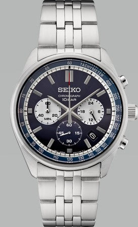 The Seiko Watch - Essentials - SSB427 features a silver metal band, striking blue dial with three subdials, date window, and tachymeter markings on the outer rim.