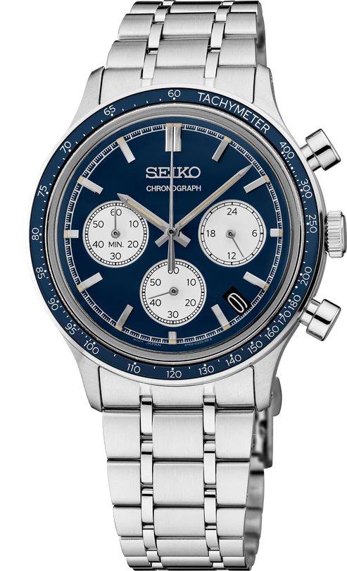 The Seiko Watch - Essentials - SSB477 features a blue dial, silver markers, three subdials, a tachymeter bezel, and a stainless steel link bracelet—ideal for fans of motor sports style.