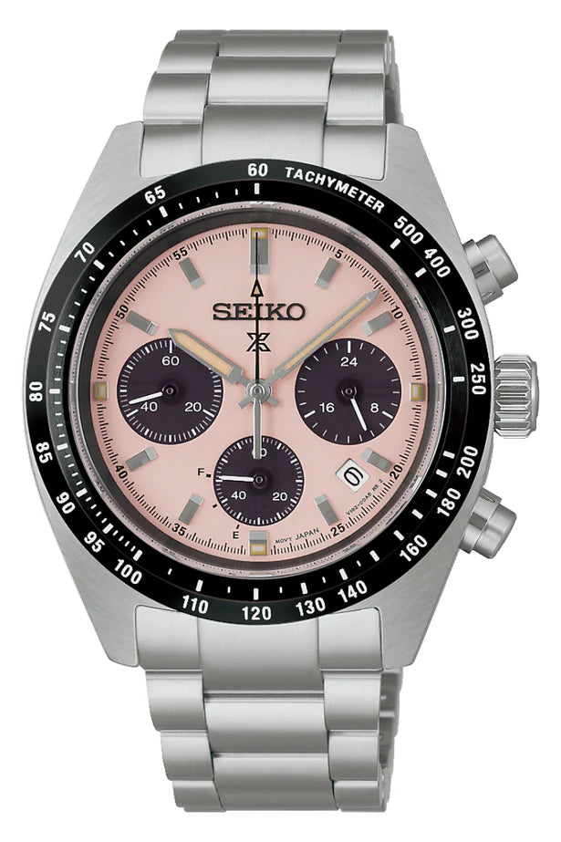 The Seiko Prospex Speedtimer Solar SSC963 is a silver wristwatch with a metal band, pink dial, black subdials, date window, black tachymeter bezel, three side buttons, solar power (Caliber V192), and luminescent hands and markers.