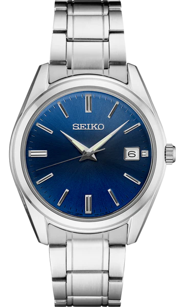 The Seiko Watch - Essentials - SUR309 is a mens stainless steel watch with a metallic band, blue sunburst dial, silver markers and hands, and a date window at 3 o’clock by Seiko.