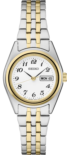 The Seiko Essentials SUR438 features a two-tone stainless steel band, white dial with black Arabic numerals, gold bezel, and day-date display at 3 o'clock.