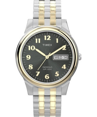 The Timex Watch - Main Street - T264819J by Timex features a black dial, gold numerals, silver and gold-tone bezel, two-tone metal band, and day-date display on the right side.
