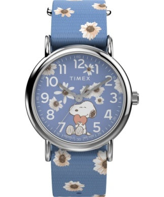 The Timex Peanuts Weekender TW2W33300JT features a blue strap, white daisy details on the face, and Snoopy hugging a heart at the center. White hands and numbers complete this charming Timex watch.