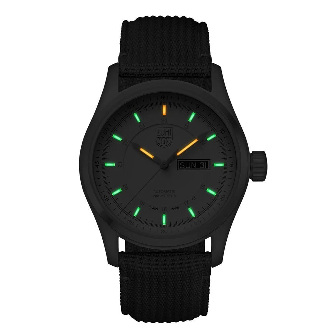 The Luminox Watch - Atacama Field Automatic - XL.1907.NF features a black case, fabric band, glowing green and orange markers, day-date display (SUN 31), and Swiss automatic movement with illuminated hands for night visibility.