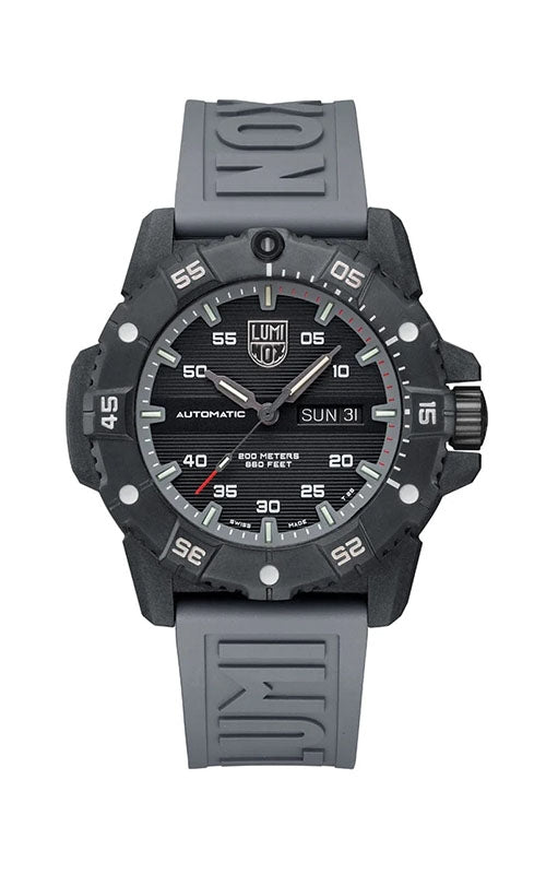 The Luminox Master Carbon SEAL Automatic XS.3862 is a black and grey wristwatch featuring a CARBONOX+ case, round face with bold white markers and grey numerals, day-date display, and a rubber strap embossed with the Luminox logo.