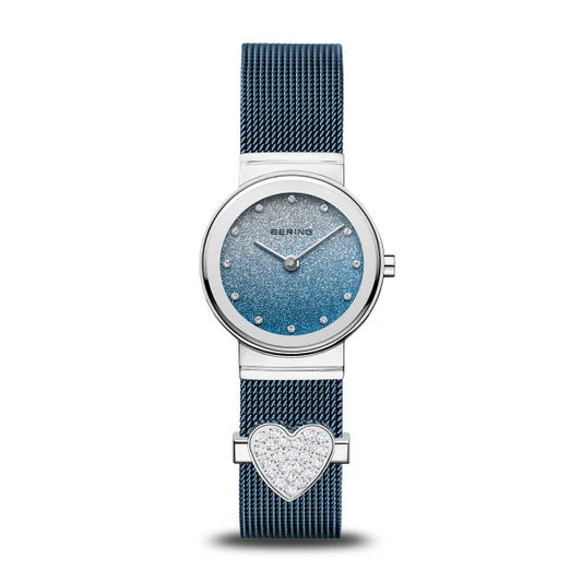 The Bering Watch - Polished Silver w/ Charm (10126-3073-GWP) features a blue mesh band, round gradient dial, silver markers, and a crystal heart—a stylish Valentine’s Day gift from Bering for someone special.