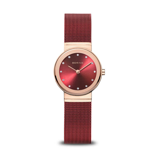 Introducing the Bering Watch - Classic Rose Gold - 10126-363 by Bering: a women's timepiece featuring a rose gold case, a vivid red Milanese mesh strap, and an eye-catching red sunray dial. The minimalist face is adorned with sparkling crystal hour markers and two hands, creating an elegant and refined look.