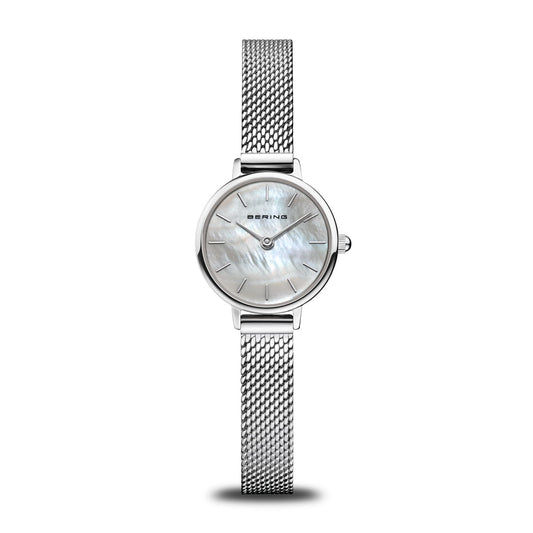 The Bering Watch - Classic Collection - 11022-004 is a women's watch with a sleek Milanese mesh strap, round white mother-of-pearl dial, minimalistic hour markers, and the BERING brand name on the face.