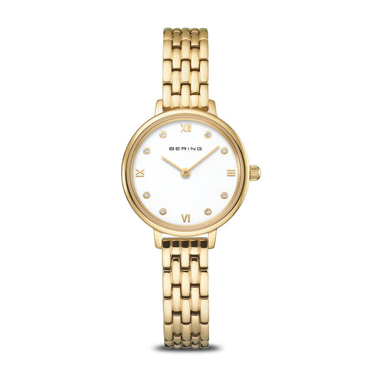The Bering Watch - Classic Collection 11028-734 is a women's gold stainless steel watch with a round white dial, gold Roman numerals at 12, 3, 6, and 9 o'clock, crystal hour markers, and a stylish gold linked bracelet band.
