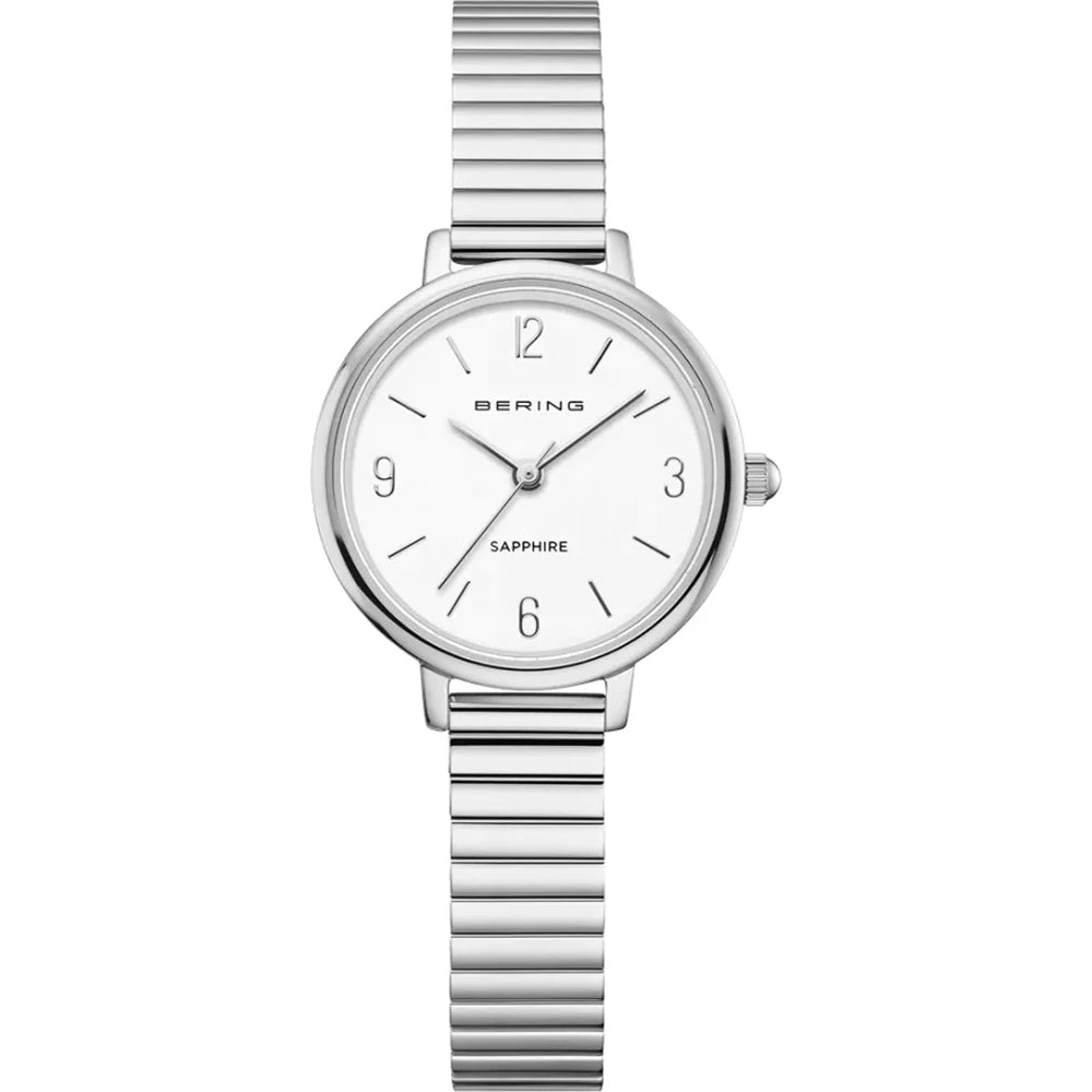 The Bering Watch - Classic Collection 11028-904 features a silver stainless steel band, minimalist white face, marked 12/3/6/9, silver markers and hands, plus “Bering” and “Sapphire” on the dial—an elegant women’s watch.
