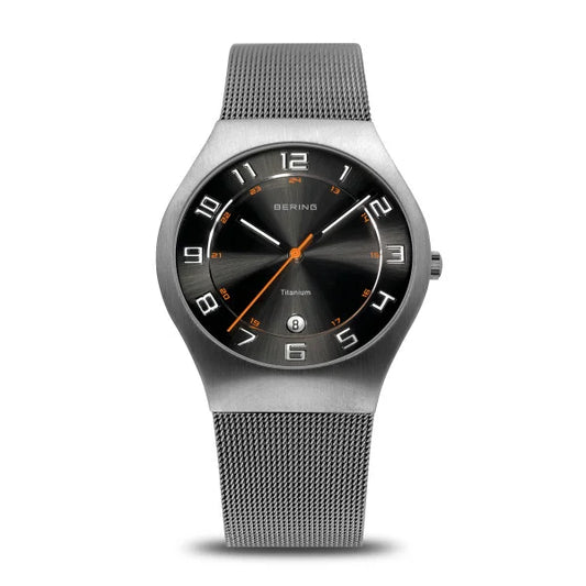 The Bering Watch - Mens Ultra-Light Titanium 11937-007 features a silver titanium case, black dial with white numerals and orange accents, mesh metal band, and displays hours, minutes, seconds plus a date window above 6 oclock.