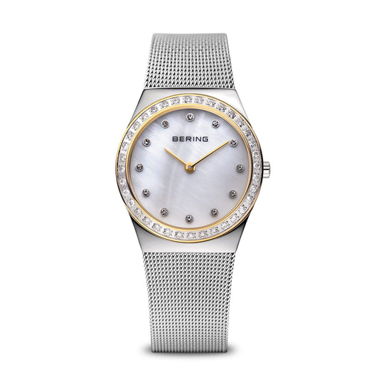 The Bering Watch - Polished Silver - 12430-010 by Bering features a stainless steel mesh band, round white mother-of-pearl face, gold bezel, and crystal hour markers in a minimalistic, numeral-free design.