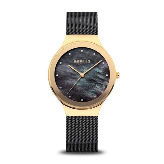 The Bering Classic Collection Womens Watch (12934-132) features a gold case, black mesh band, black mother-of-pearl dial, crystal hour markers, and gold hands—an elegant sapphire crystal timepiece for any occasion.