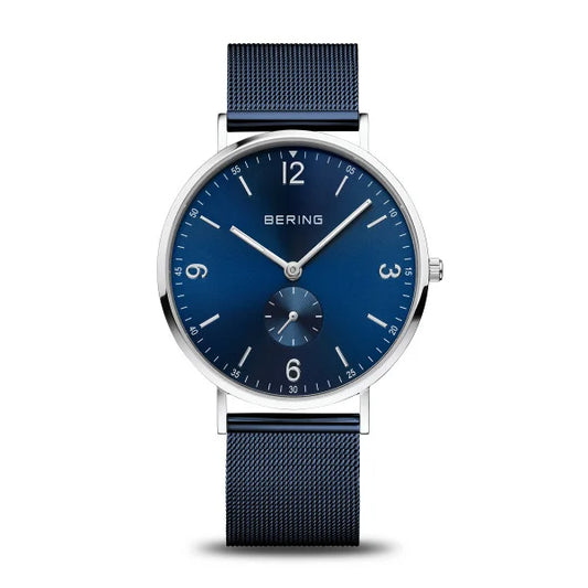 The Bering Watch - Classic Polished Silver (14040-307) features a blue mesh strap and dial, silver markers and hands, a subdial above 6 o’clock, and a minimalist men’s stainless steel design from Bering.