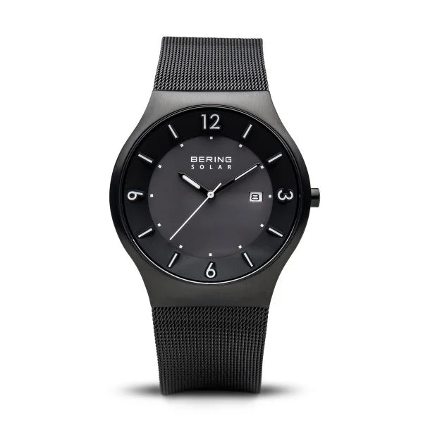 The Bering Watch - Mens Black Slim Solar Collection (14440-222) features a black stainless steel mesh band, minimalist dial with silver hour markers, date window at 3 o’clock, and numerals only at 3, 6, 9, and 12.