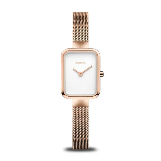 The Bering Watch - Petite Square Collection - 14520-364 features a rose gold rectangular case, minimalist white face, slender gold hands, and a mesh band from Bering, shown on a white background.