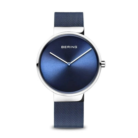 The Bering Watch - Classic Collection Unisex Blue (14539-307) features minimalist Danish design with a blue mesh band, round blue dial, silver hands, and slim silver bezel. Photographed against a white background.