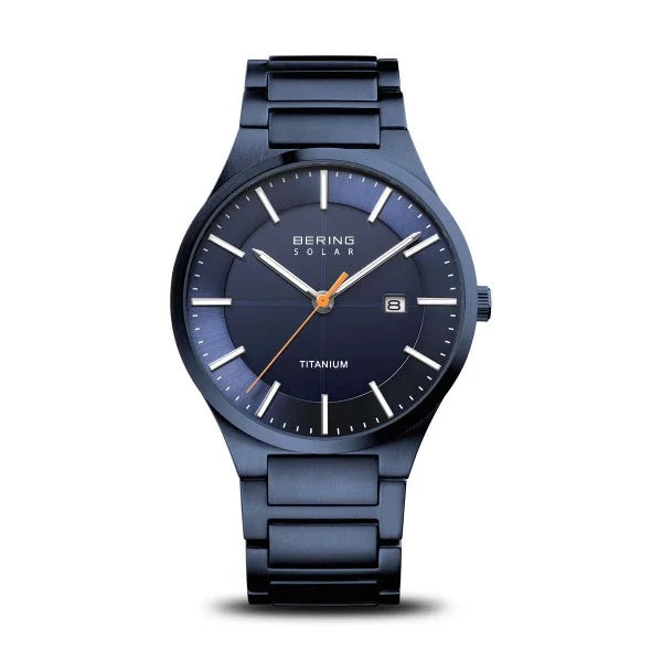The Bering Watch - Ultra-Slim Solar Titanium (15239-797) by Bering, featuring a dark blue dial, minimalist white markers, a date window at 3 o’clock, and a sleek metal band, is displayed on a plain white background.
