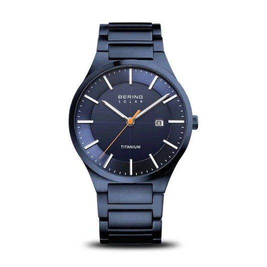 The Bering Watch - Ultra-Slim Solar Titanium (15239-797) by Bering, featuring a dark blue dial, minimalist white markers, a date window at 3 o’clock, and a sleek metal band, is displayed on a plain white background.