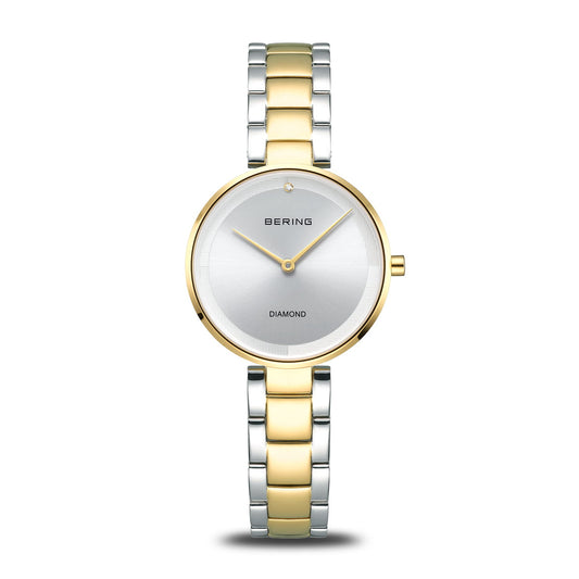 The Bering Watch - Diamond - 17529-710 features a silver round face, minimalist design, single diamond at 12 o’clock, BERING logo at center, and an elegant two-tone gold and silver stainless steel band for women.