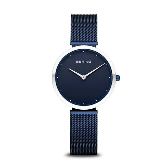 The Bering Watch - Ladies Polished Blue Classic Collection (18132-397) features a minimalist round blue face, silver hands, no numbers, and a blue mesh band from brand Bering, shown against a white background.