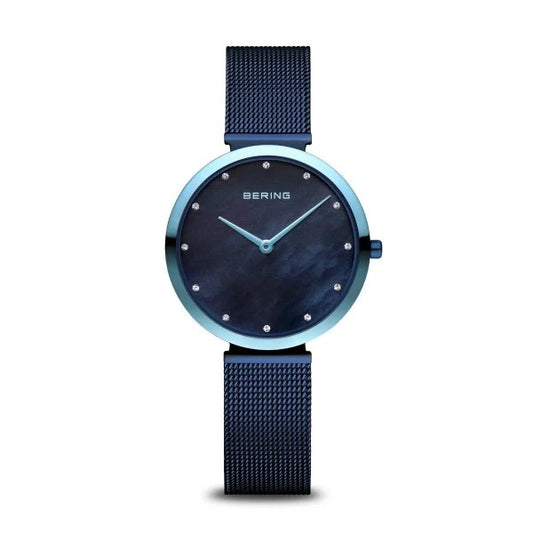 The Bering Watch - Classic Collection Womens Blue (18132-398) features minimalist Danish design with a round dark blue face, small crystal hour markers, and a blue mesh stainless steel band, shown on a white background.