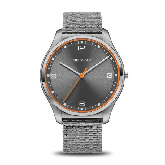 The Bering Watch - Ultra Slim Mens Brushed Grey (18342-577) features Danish design, a gray fabric strap, brushed gray dial, silver hour markers, an orange second hand and ring; time is set to 10:09:31.