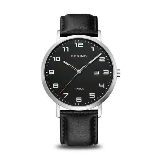 The Bering Mens Titanium Watch 18640-402 features a brushed silver case, black dial, silver markers and hands, date window at 3 o’clock, black leather strap, and BERING TITANIUM branding on the face.