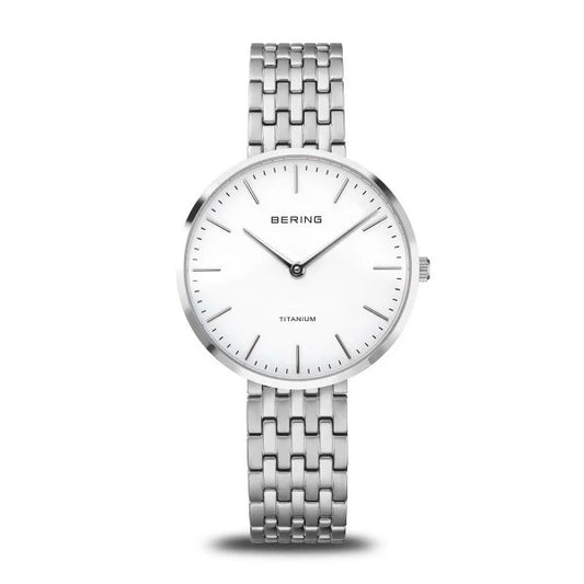 The Bering Watch - Titanium Womens Silver (19334-004) features a minimalist white face with black hour markers, silver hands, and a silver titanium link band, shown against a plain white background.