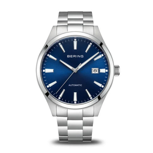The Bering Men's Automatic Watch 19842-707 features a silver stainless steel link bracelet, blue dial, silver markers and hands, date window at 3 o’clock, and “BERING AUTOMATIC” on the face—a stylish mechanical timepiece.