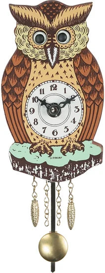 The Alexander Taron Inc. Engstler Black Forest Owl Clock (201QP) features a vintage owl shape with large eyes, a clock face on its body, two pendulums, decorative chains below, and is perched on a branch.