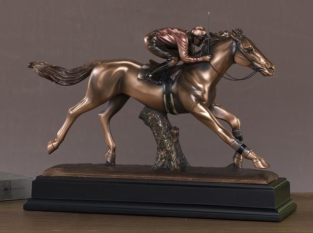 The Treasure of Nature JOCKEY (54037) bronze statue features a jockey on a galloping horse, mounted on a rectangular black base and set against a plain brown background. Dimensions: 16W x 11.5H.