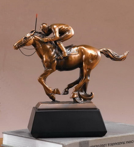 The Treasure of nature "Treasures of Nature - Horse with Jockey - 54079" features a bronze horse and jockey figurine on a dark rectangular base—an eye-catching accent for collectors and book displays.