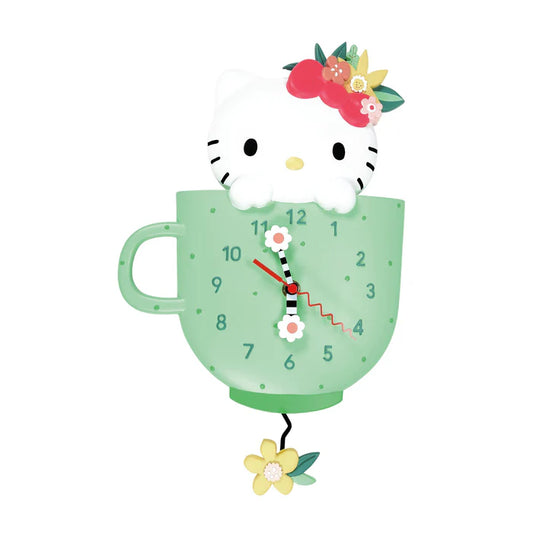 The Enesco Allen Designs Clock - Hello Kitty Wall Clock (6015809) features Hello Kitty peeking from a green teacup, with a red flower on her head and floral-decorated clock hands—a charming addition to any Sanrio fans wall.