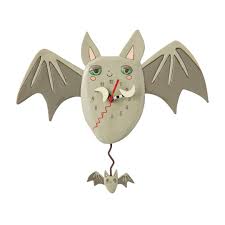The Enesco Allen Designs Clock - Batitude Clock (6018050) is a charming gray bat wall clock with large wings, pointy ears, a smiling face, and a swinging mini bat pendulum. Red and black hands add the finishing touch.